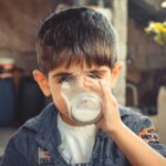 photo of boy drinking glass of milk